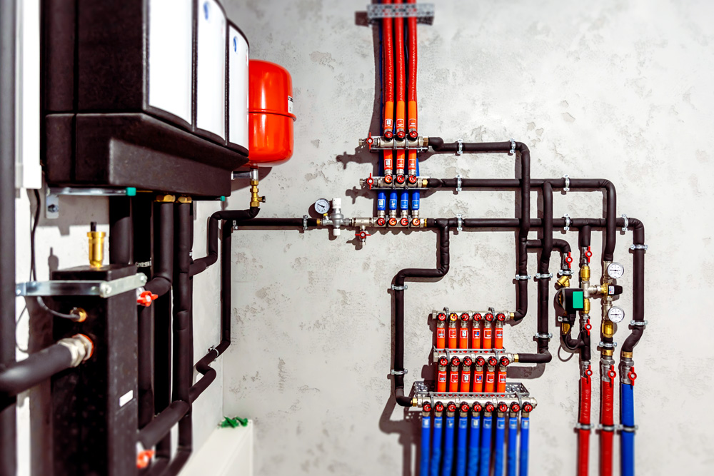 Heizungsverteiler in einem modernen Gebäude­technikraum, in dem der Heizkreislauf für den Einsatz von EndoTherm optimiert werden kann.