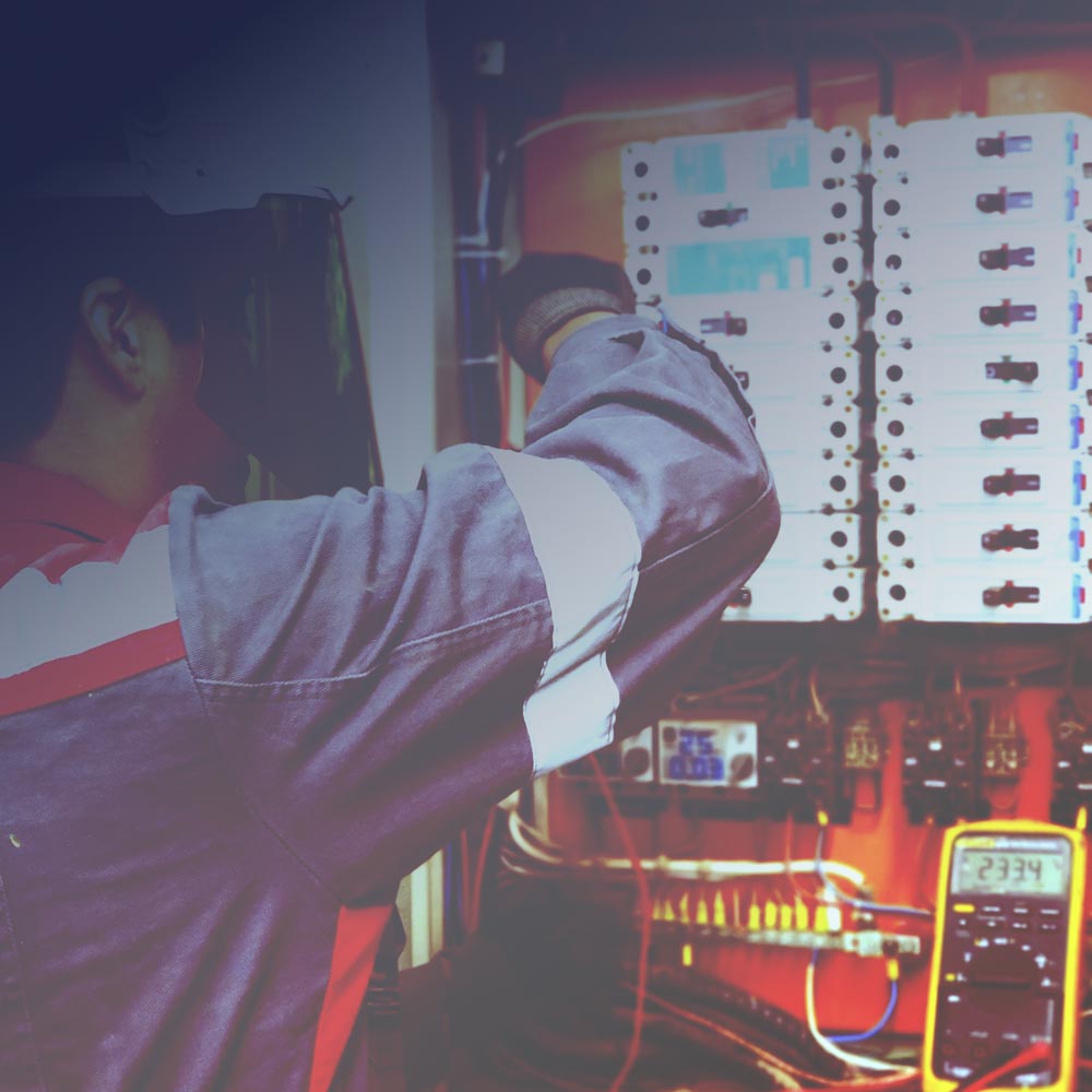 Techniker prüft einen elektrischen Schaltschrank einer Kälte- und Klimaanlage, in den Smartcool als zusätzliche Steuereinheit integriert werden kann.